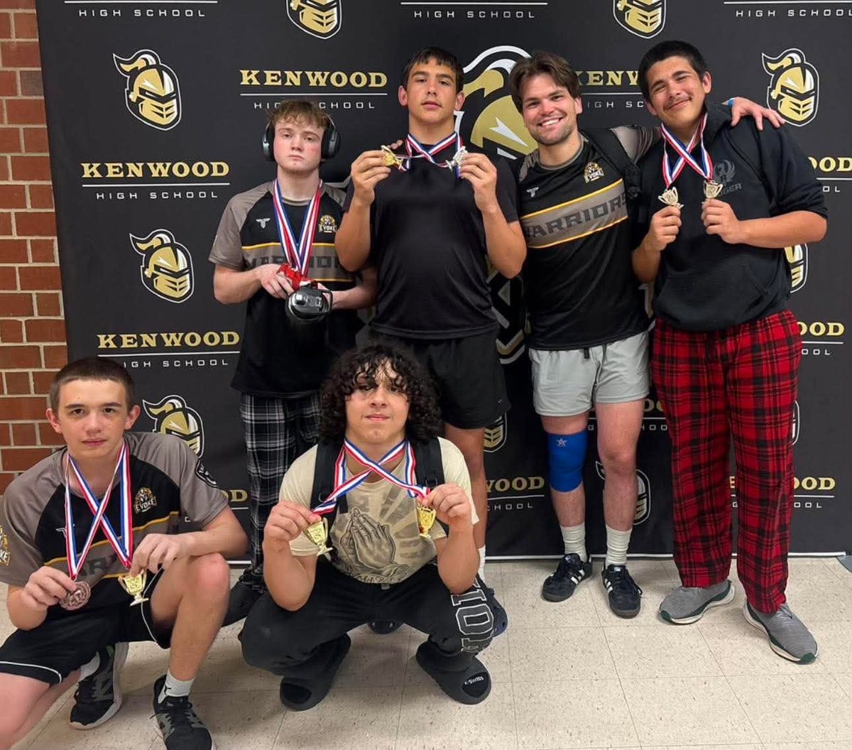 Evoke Warriors wrestlers holding up their medals after a tournament